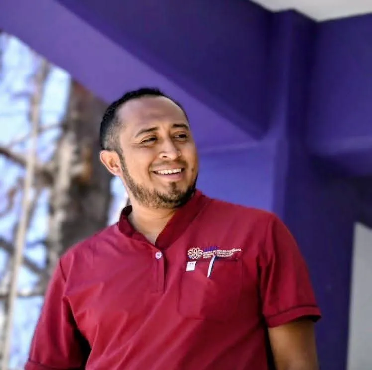 Miguel Colorado sonriendo con polo del consultorio